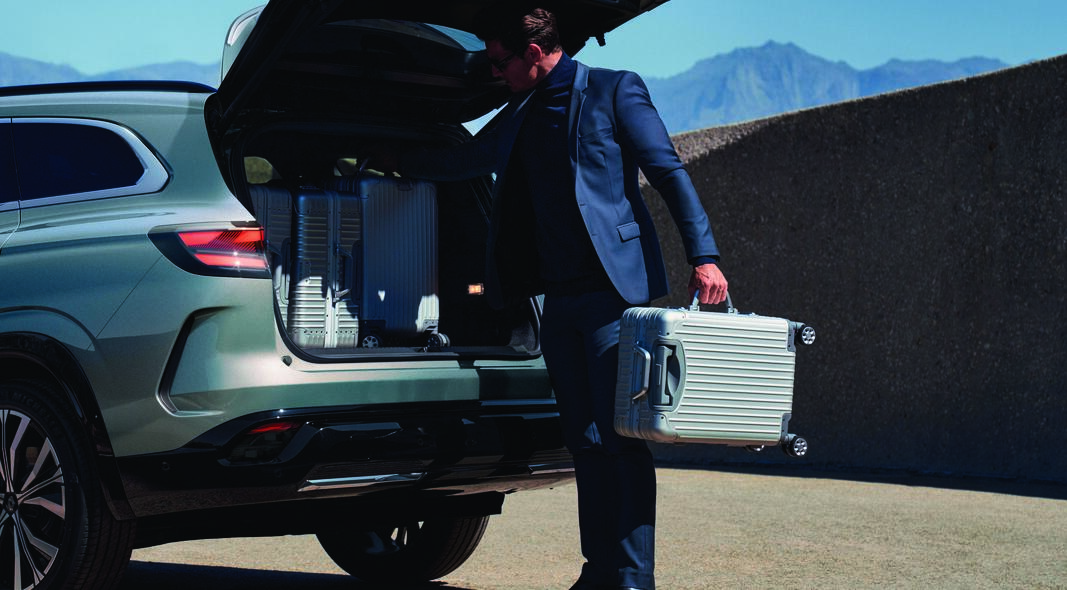 Man loading luggage into a brand new Renault Espace trunk for European road trip